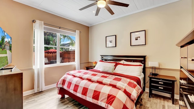 bedroom featuring light hardwood / wood-style floors, crown molding, and ceiling fan