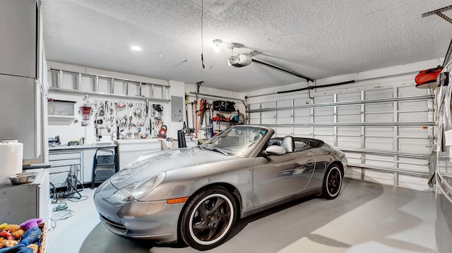 garage with a workshop area, a garage door opener, and electric panel