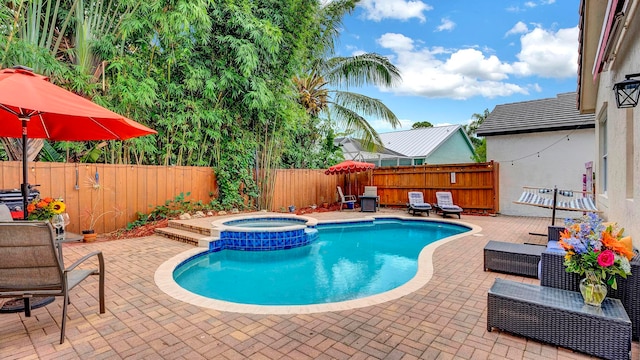 view of swimming pool featuring an in ground hot tub and a patio