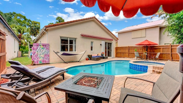 view of swimming pool with an in ground hot tub, a fire pit, and a patio area