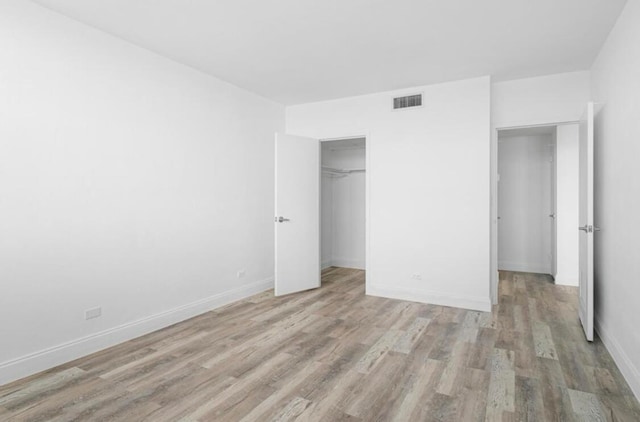 unfurnished bedroom with light hardwood / wood-style flooring and a closet