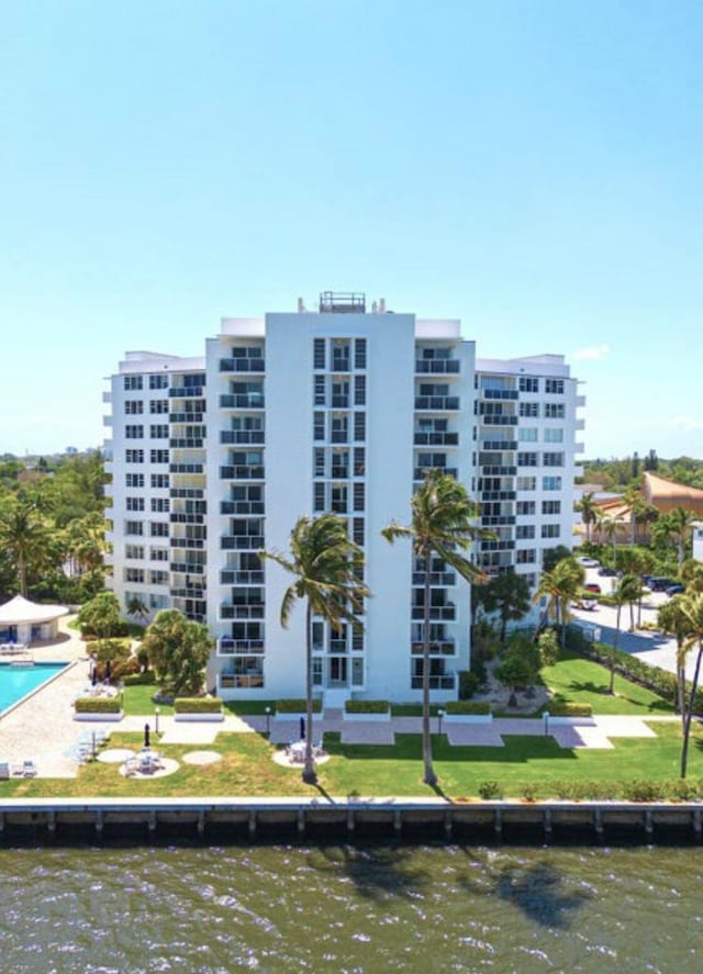 view of building exterior featuring a community pool and a water view