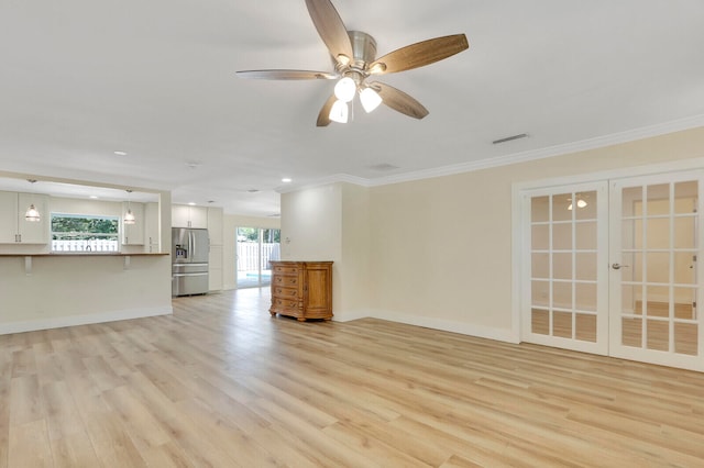 unfurnished living room featuring ornamental molding, light wood-type flooring, ceiling fan, and french doors