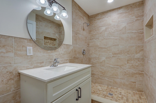 bathroom with tile walls, backsplash, vanity, and tiled shower