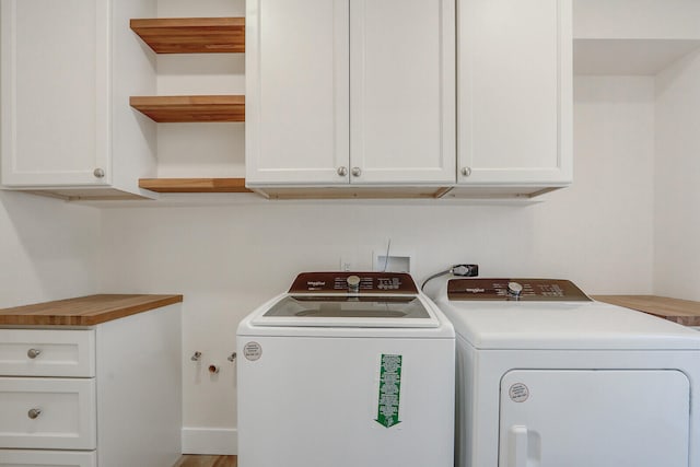 laundry room featuring washer and clothes dryer and cabinets