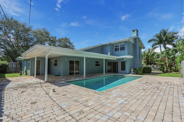 back of property featuring a fenced in pool and a patio area