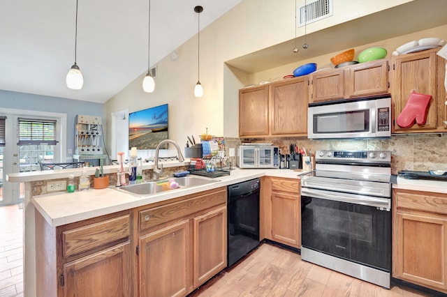 kitchen with a peninsula, hanging light fixtures, stainless steel appliances, light countertops, and a sink