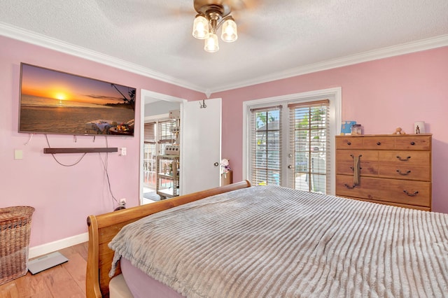 bedroom featuring access to outside, crown molding, a textured ceiling, light wood-type flooring, and baseboards