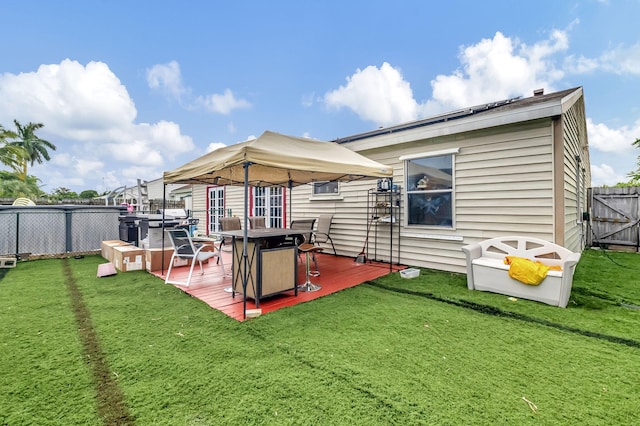 back of house featuring fence, a deck, and a yard