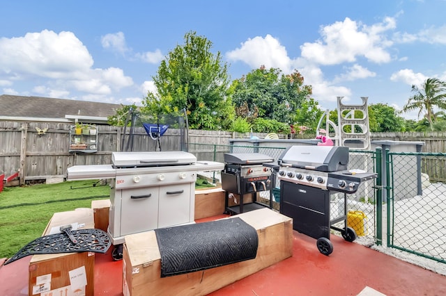 view of patio featuring a gate, a grill, and fence