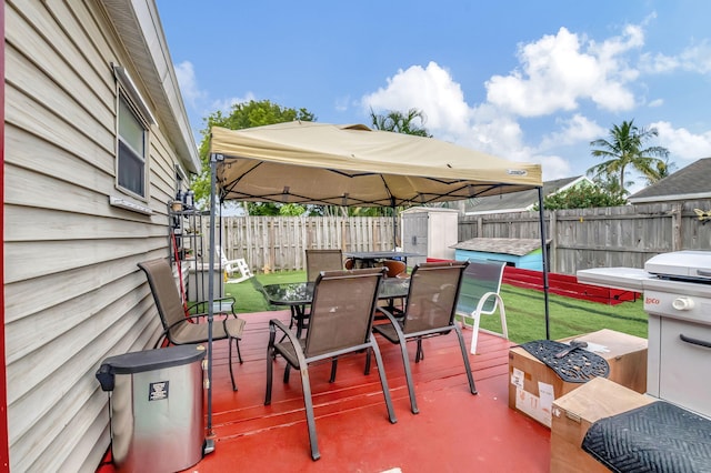 view of patio / terrace featuring a storage shed, a fenced backyard, outdoor dining area, and a gazebo