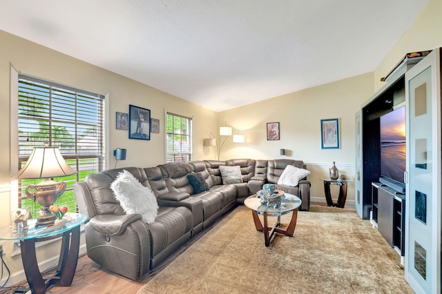 living room with lofted ceiling, wood finished floors, and baseboards