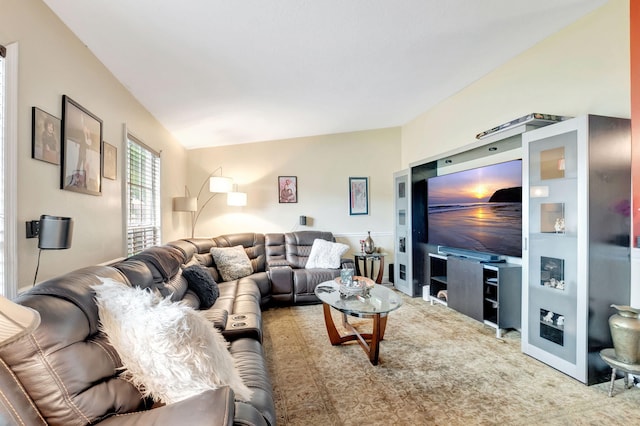 carpeted living area with lofted ceiling