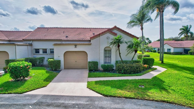 mediterranean / spanish house with a garage and a front lawn