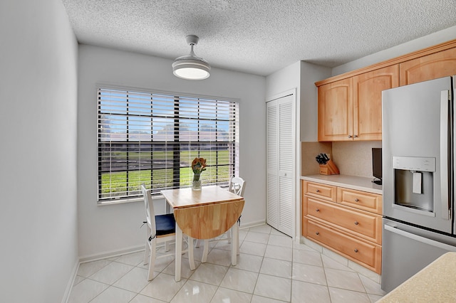 dining room featuring a textured ceiling, built in desk, and light tile patterned floors