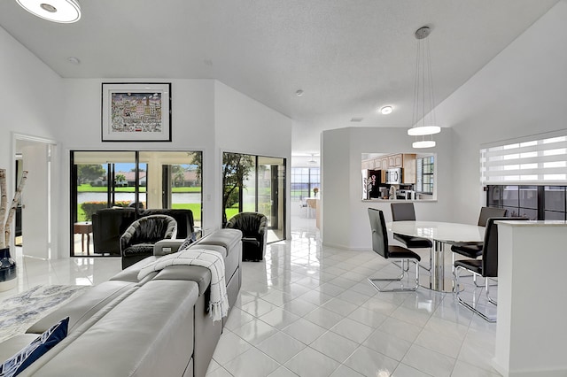 tiled living room featuring high vaulted ceiling, a textured ceiling, and french doors