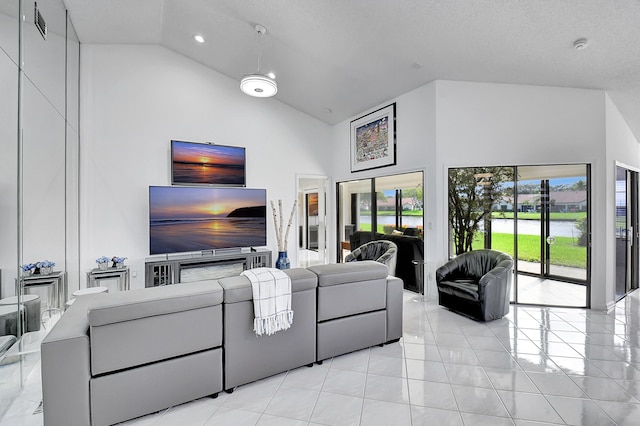 tiled living room featuring a textured ceiling and high vaulted ceiling