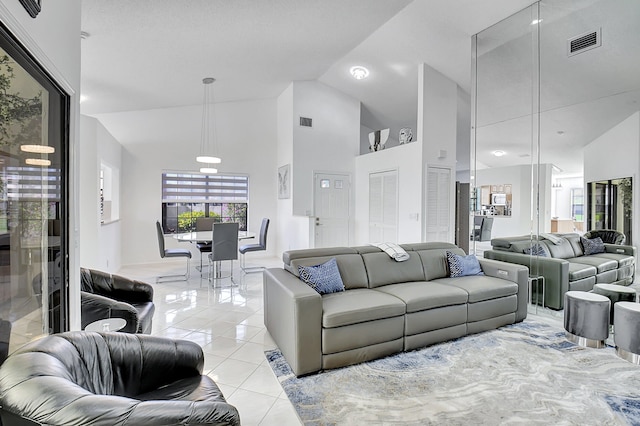 living room featuring high vaulted ceiling and light tile patterned flooring