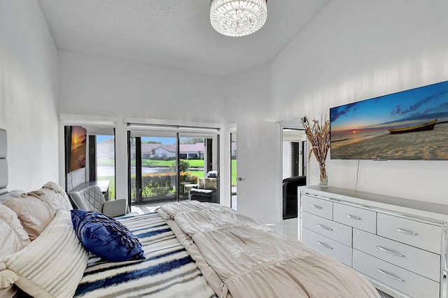 bedroom with high vaulted ceiling, a textured ceiling, and access to exterior