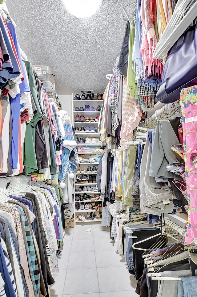 walk in closet with light tile patterned floors