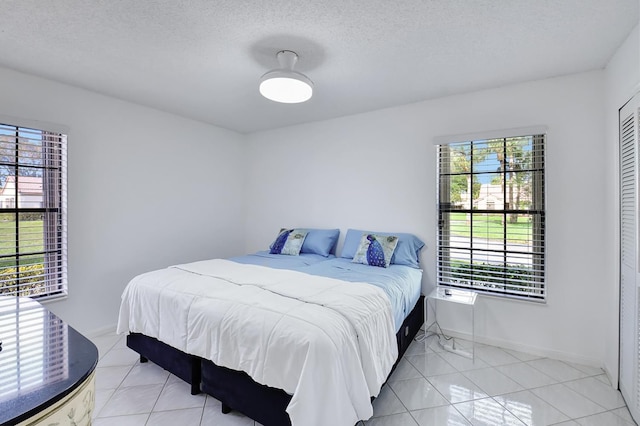 tiled bedroom featuring a textured ceiling