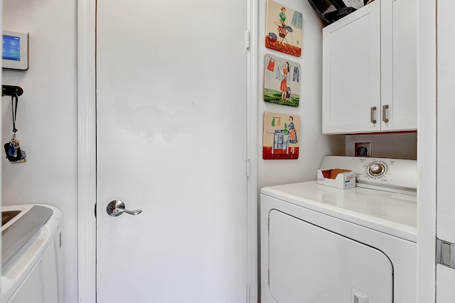 laundry room featuring washer and dryer and cabinets