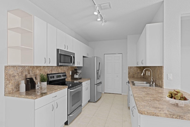 kitchen featuring a textured ceiling, appliances with stainless steel finishes, white cabinetry, and sink