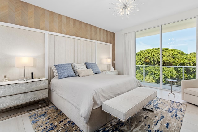 bedroom featuring access to outside, wooden walls, and a chandelier