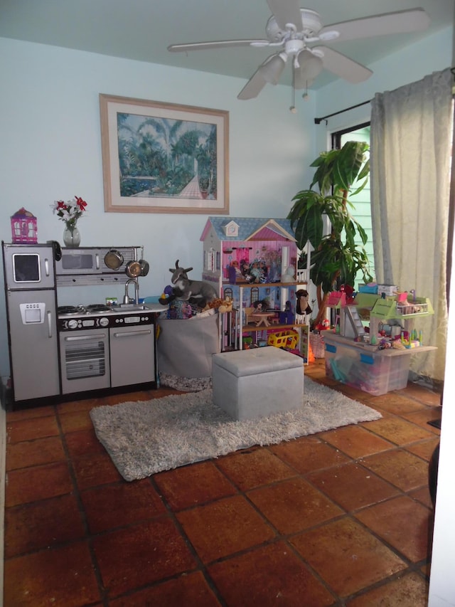 playroom featuring ceiling fan and dark tile patterned flooring