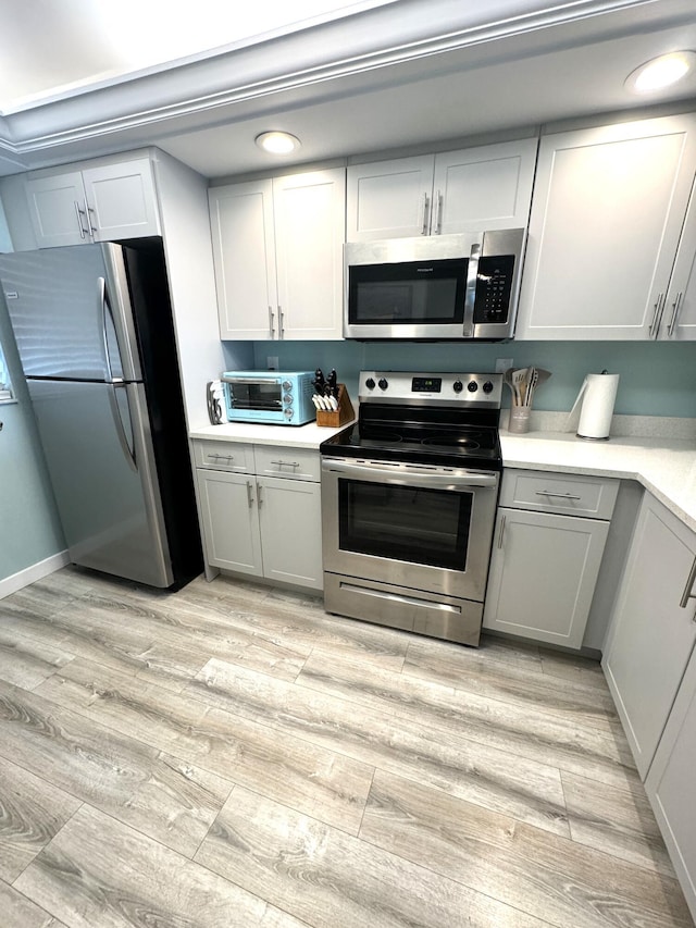 kitchen featuring gray cabinets, light hardwood / wood-style floors, and appliances with stainless steel finishes