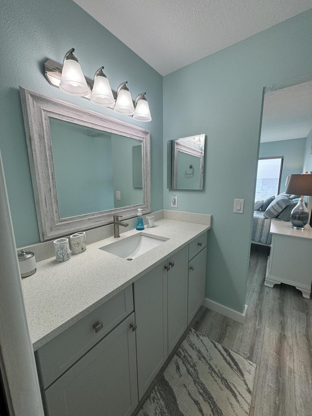 bathroom featuring vanity, a textured ceiling, and hardwood / wood-style flooring