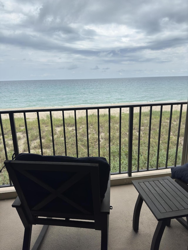 balcony featuring a water view and a view of the beach