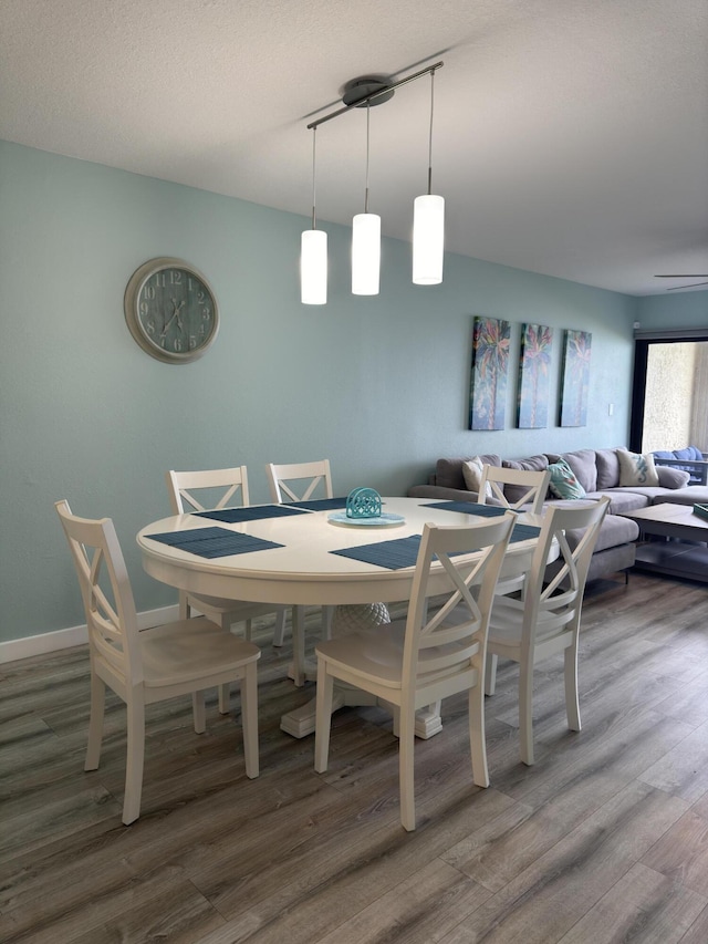 dining room with hardwood / wood-style floors and a textured ceiling