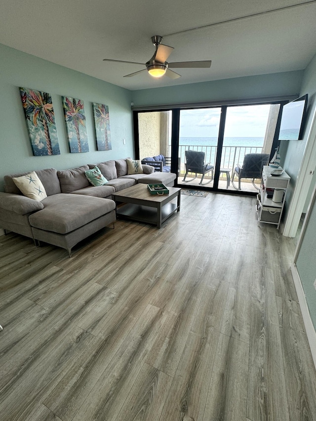 living room featuring a water view, ceiling fan, and light hardwood / wood-style floors