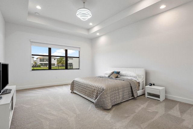 carpeted bedroom with a tray ceiling