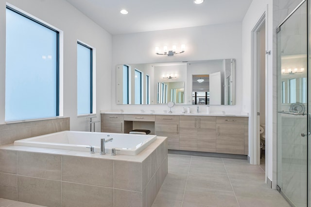 full bathroom with tile patterned floors, toilet, shower with separate bathtub, and vanity