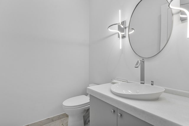 bathroom with toilet, vanity, and tile patterned floors