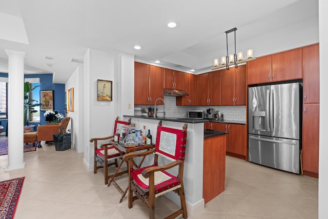 kitchen featuring appliances with stainless steel finishes, tasteful backsplash, decorative columns, light tile patterned floors, and hanging light fixtures