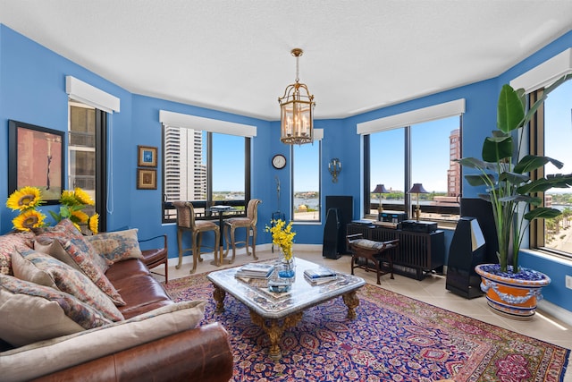 living room featuring a wealth of natural light, a notable chandelier, and light tile patterned flooring