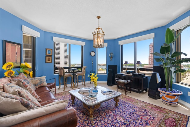 living area featuring baseboards, a healthy amount of sunlight, light tile patterned flooring, and a notable chandelier