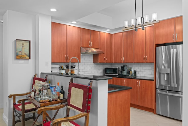 kitchen featuring light tile patterned floors, stainless steel appliances, dark countertops, decorative backsplash, and under cabinet range hood