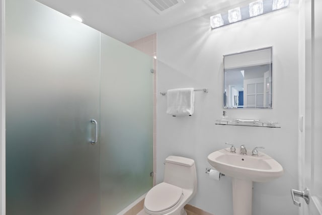 bathroom featuring toilet, a shower stall, and visible vents