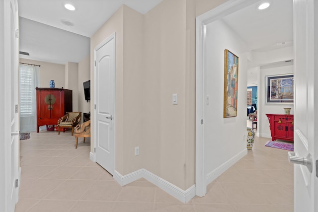 corridor with recessed lighting, light tile patterned flooring, and baseboards