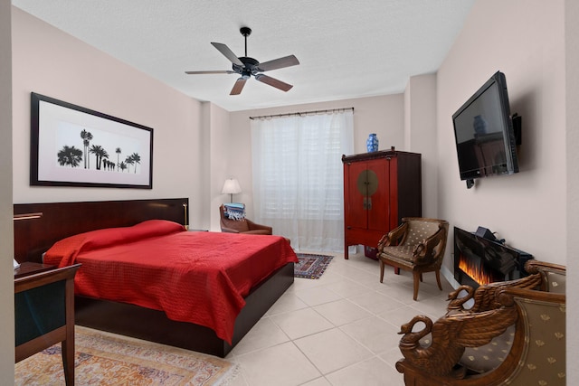 tiled bedroom with ceiling fan and a textured ceiling