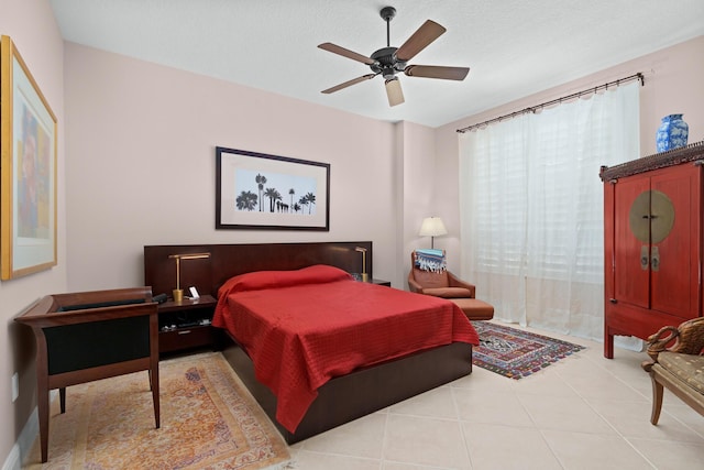 bedroom featuring a ceiling fan, tile patterned flooring, and a textured ceiling