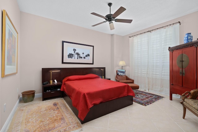 tiled bedroom featuring a textured ceiling, a ceiling fan, and baseboards