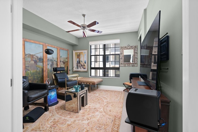 office with ceiling fan, a textured ceiling, and baseboards