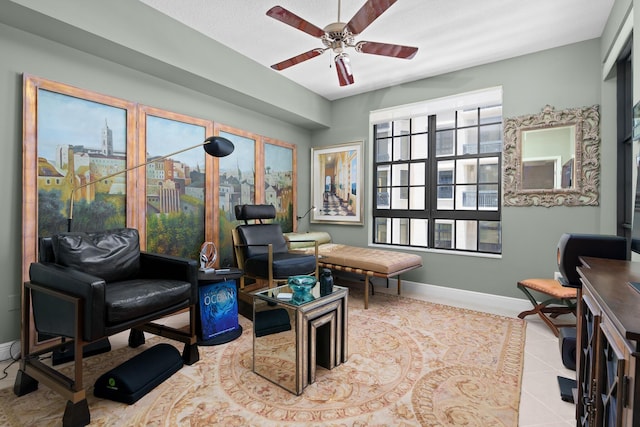 interior space with ceiling fan, a city view, tile patterned flooring, and baseboards