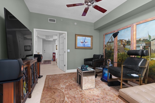 interior space with ceiling fan, light tile patterned flooring, visible vents, and baseboards