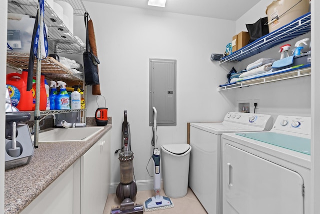 clothes washing area with laundry area, a sink, baseboards, washer and dryer, and electric panel